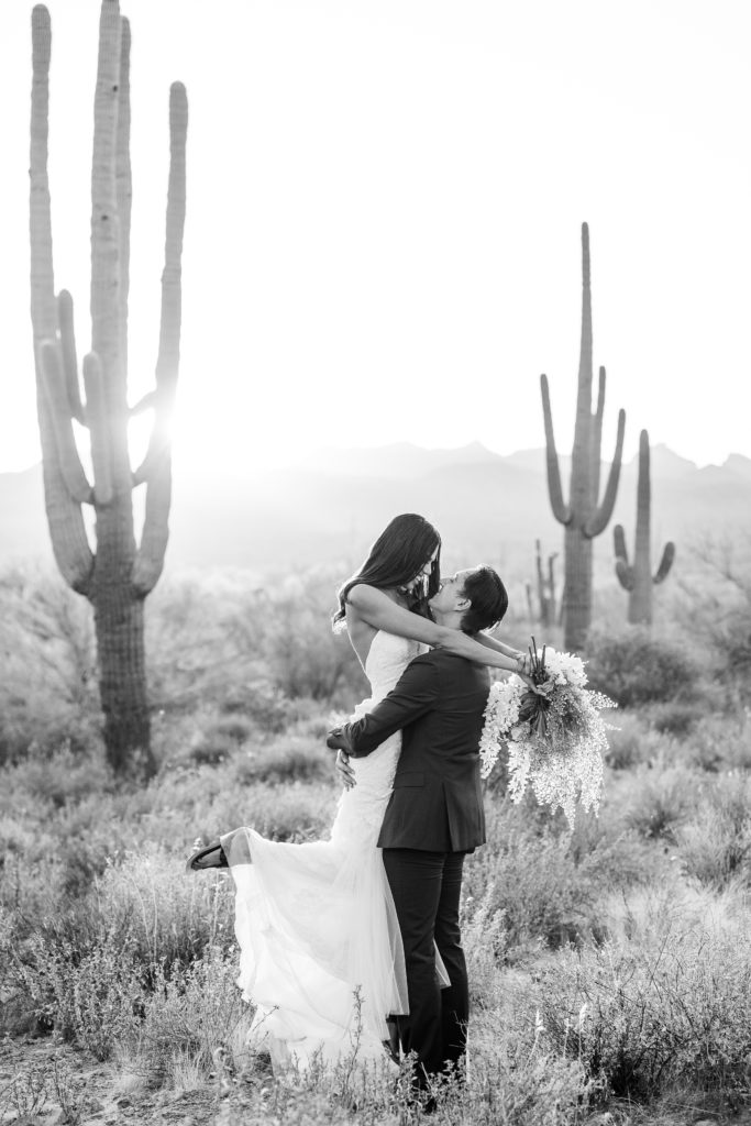 married couple next to saguaro cacti in arizona