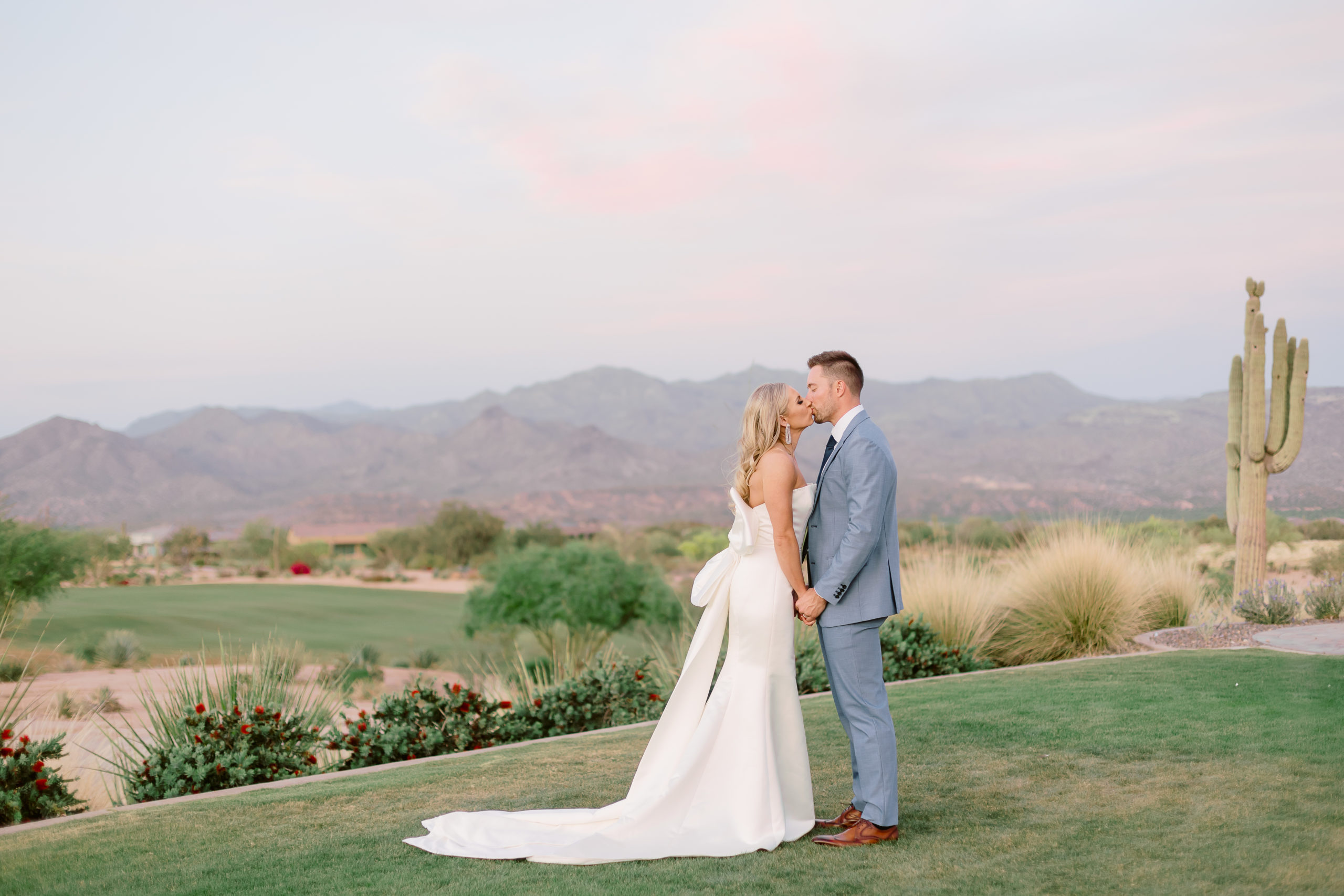 couple kisses at their desert wedding venue